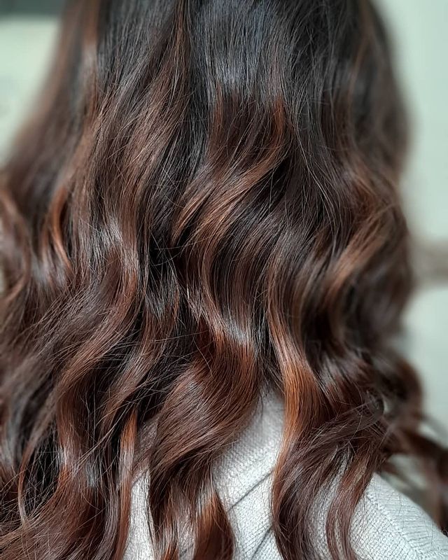 Capelli castani con highlights color cioccolato e piega a onde