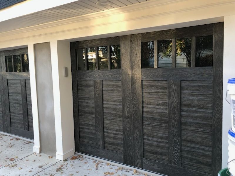 A garage door that looks like a wooden door with windows.