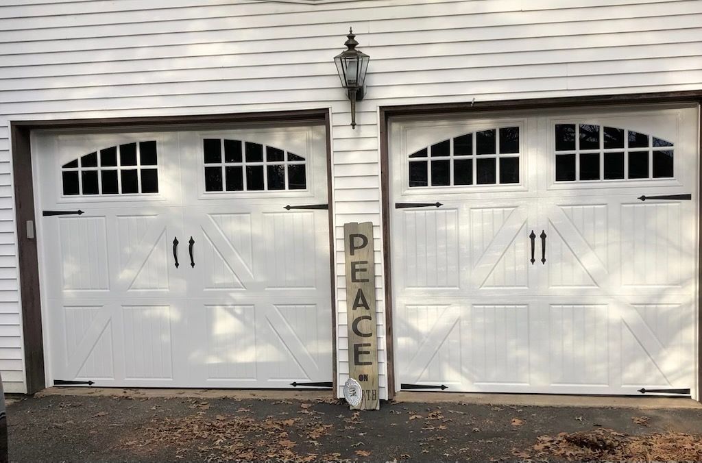 A white garage door with a sign that says peace on it.