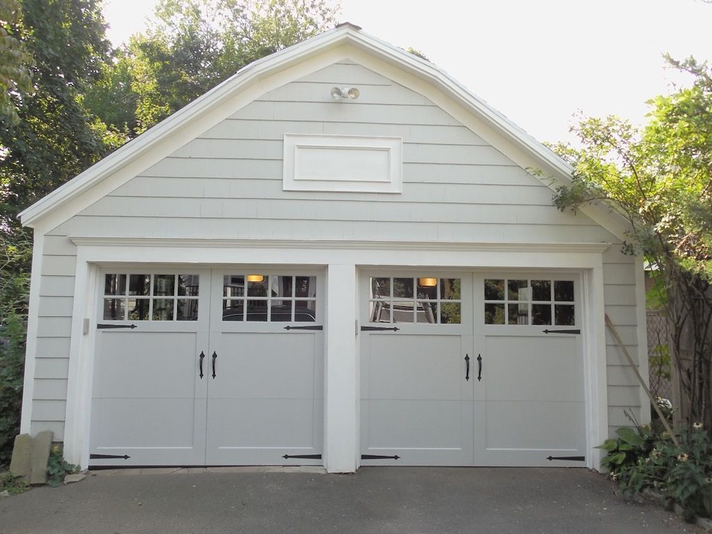 A white garage with two doors and a roof