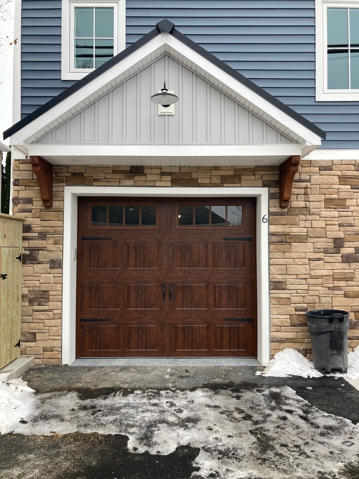 A blue house with a brown garage door
