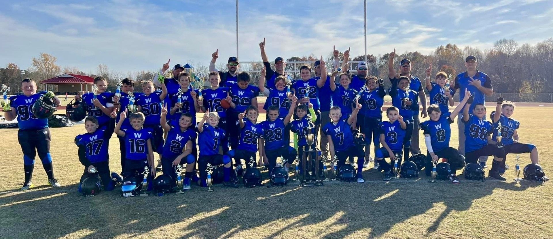 A group of children are posing for a picture on a field.