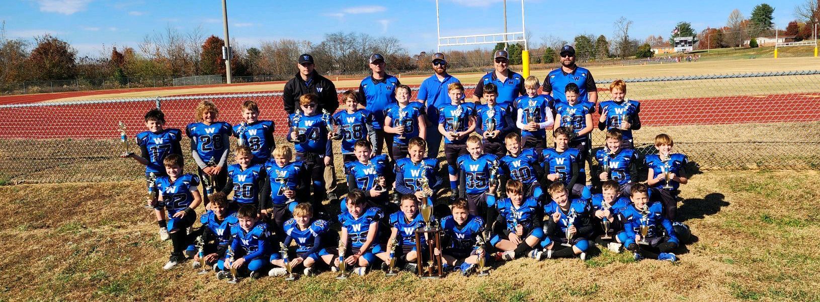 A group of children are posing for a picture on a field.