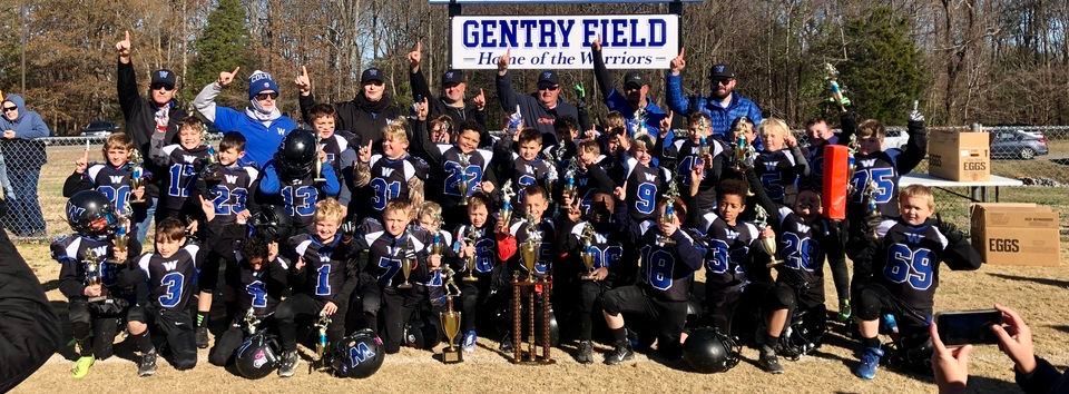 A group of football players are posing for a picture in front of a sign that says gentry field
