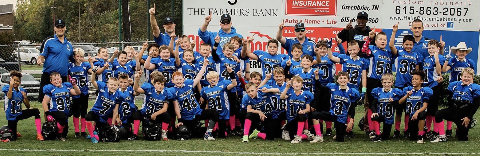 A group of children are posing for a picture on a football field.