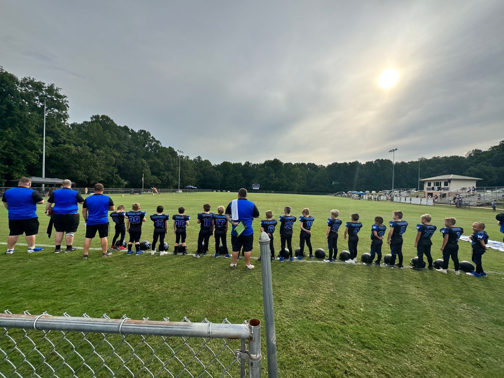 A group of people are standing in a line on a field.