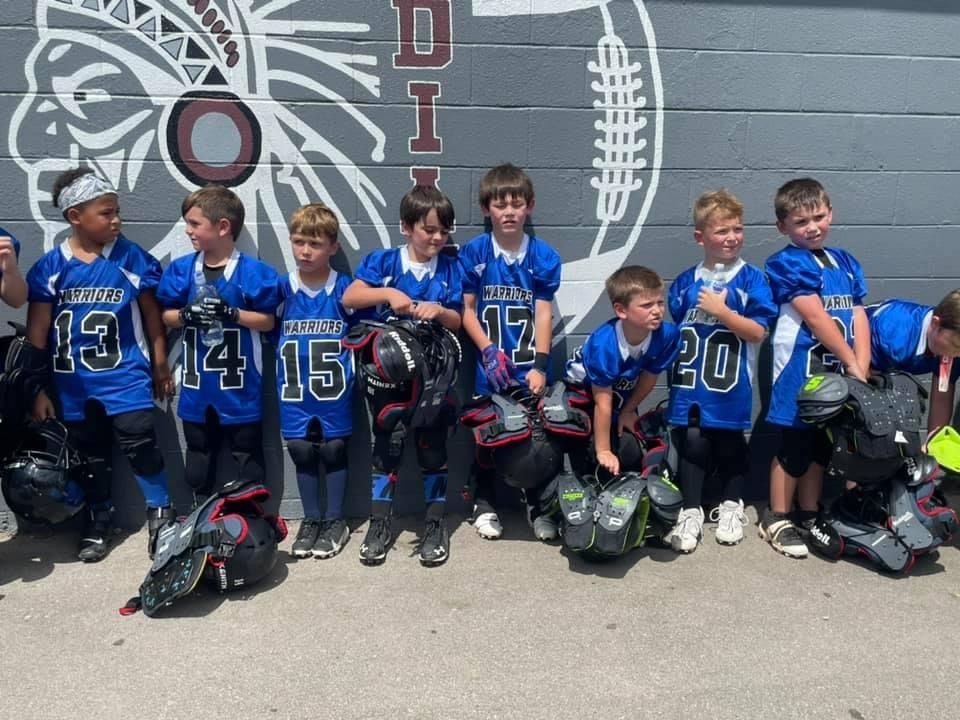 A group of young boys wearing blue jerseys with the numbers 13 14 15 and 30 on them