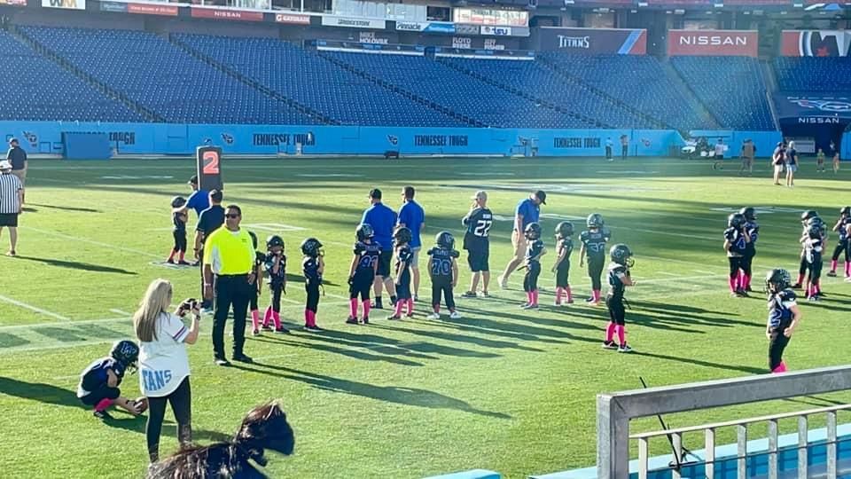 A group of children are playing football on a field.