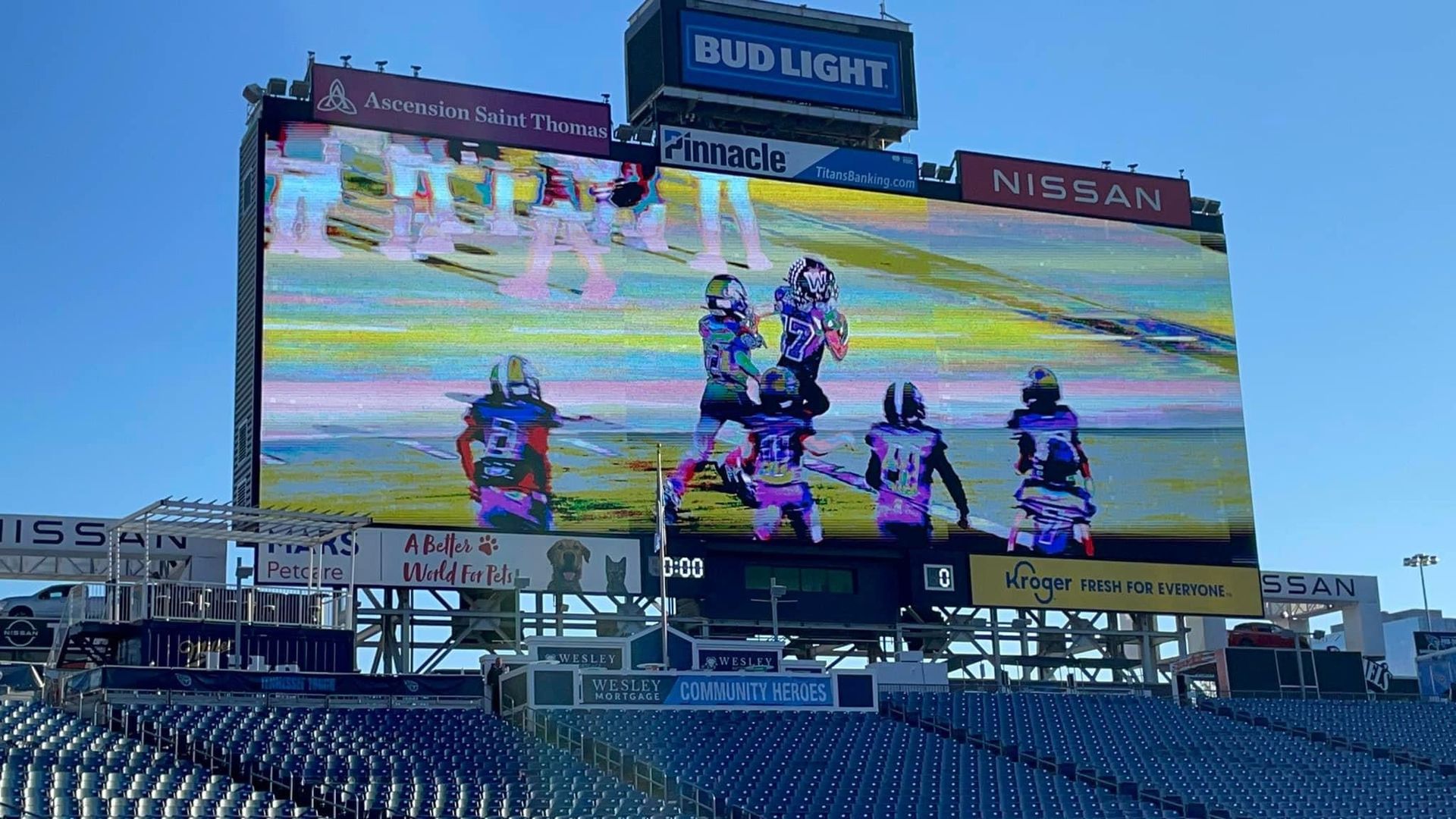 A football game is being played on a large screen at a stadium.