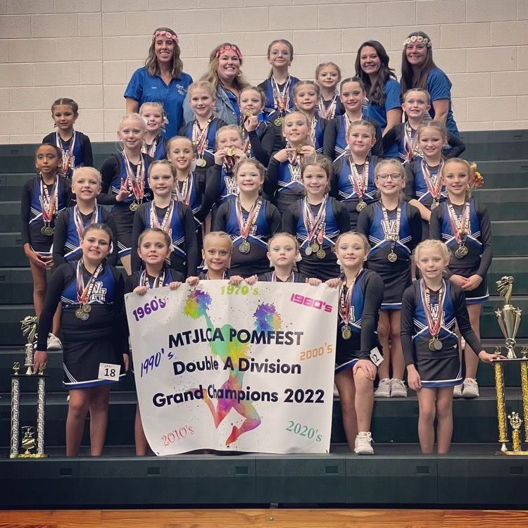 A group of cheerleaders holding a sign that says mtjlca pomfest doubt a division grand champions 2022