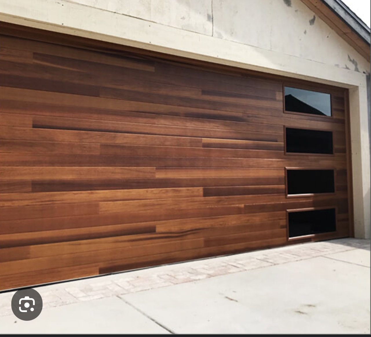 A wooden garage door with three windows on it