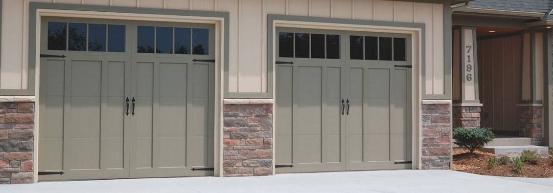 A house with two garage doors and a brick wall