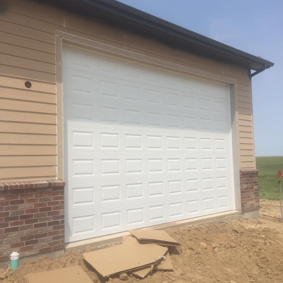 A white garage door is open on a house