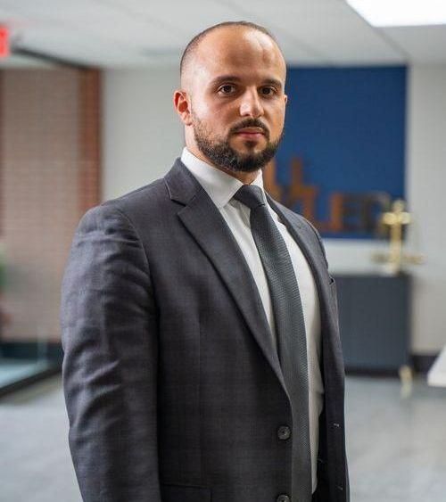 A man in a suit and tie is standing in a room.