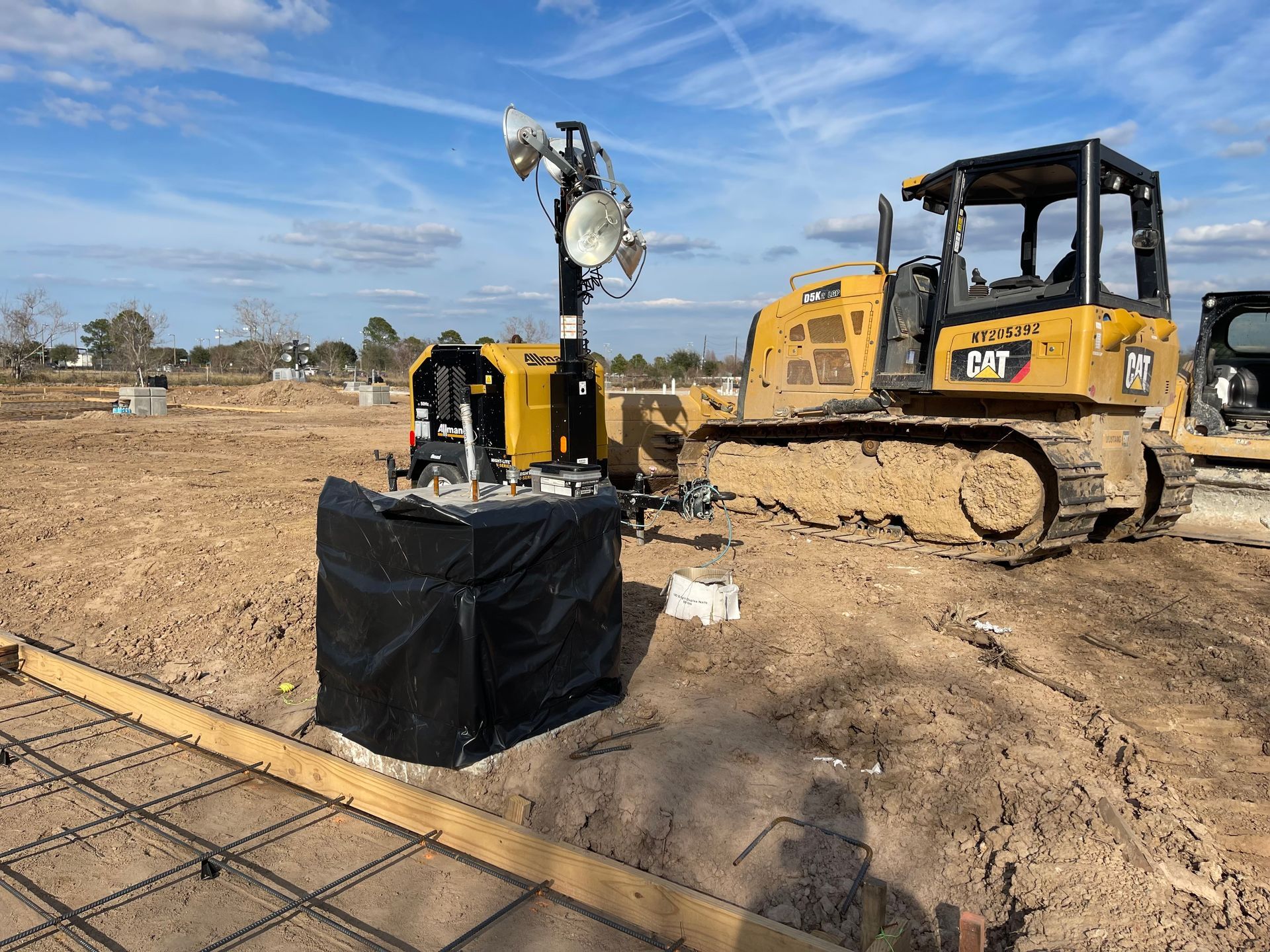 Yellow excavator digging in dirt at a construction site.