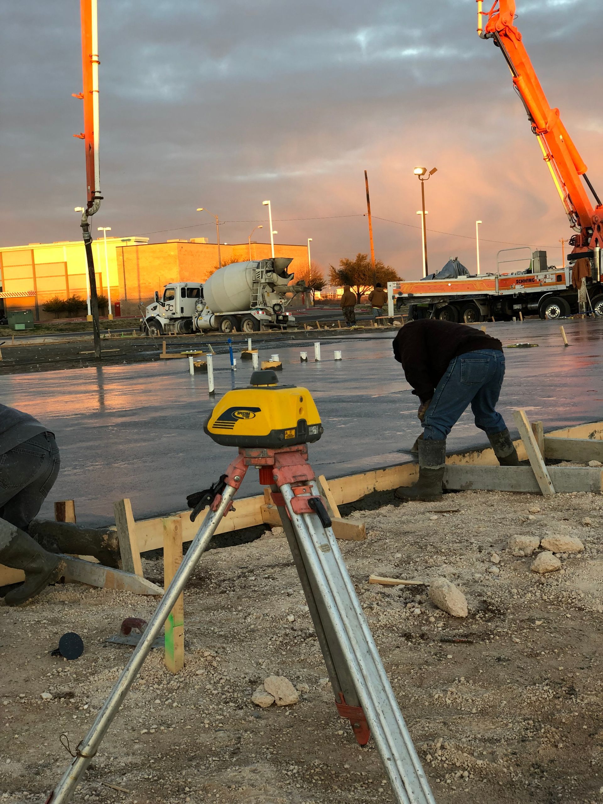 Construction workers shaking hands, smiling, wearing hard hats and safety vests.