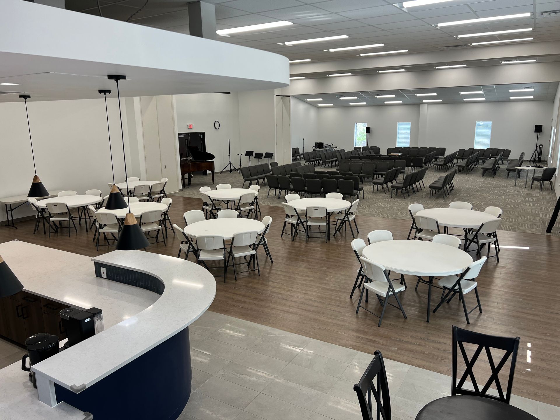 Bright modern hotel lobby with seating areas, large windows, and a column.