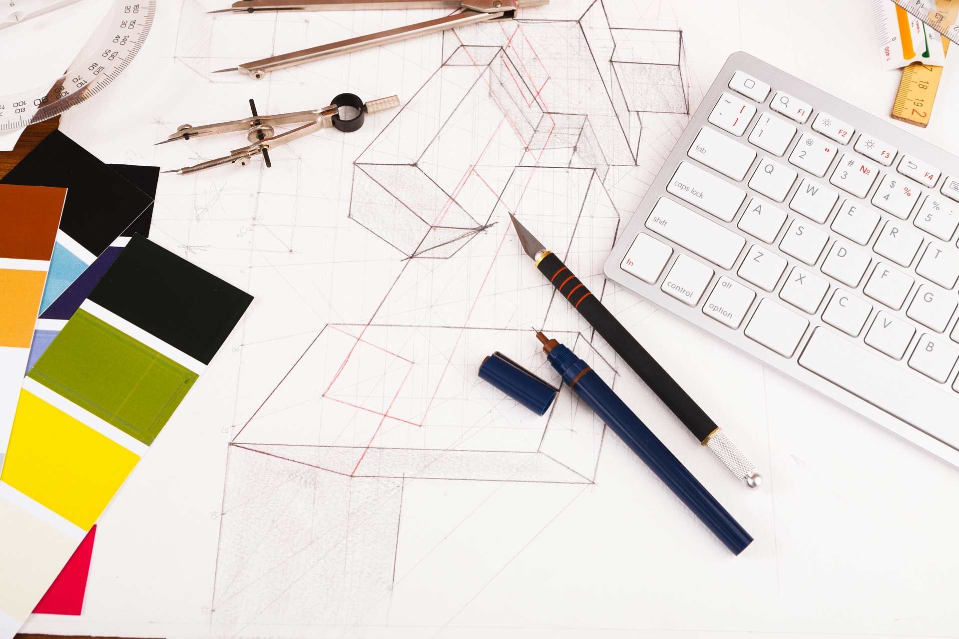 Blueprint with architectural tools, color swatches, and keyboard, suggesting design work.