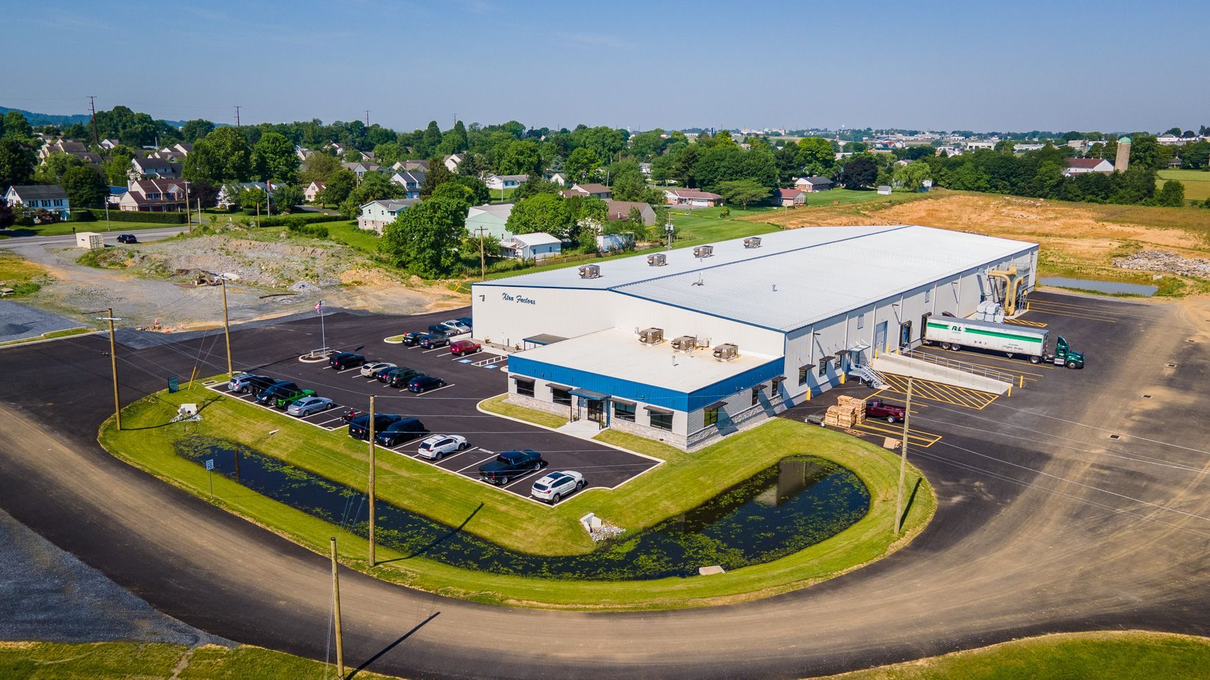An aerial view of the Xtra Factors East Earl, PA building with a parking lot in front of it.