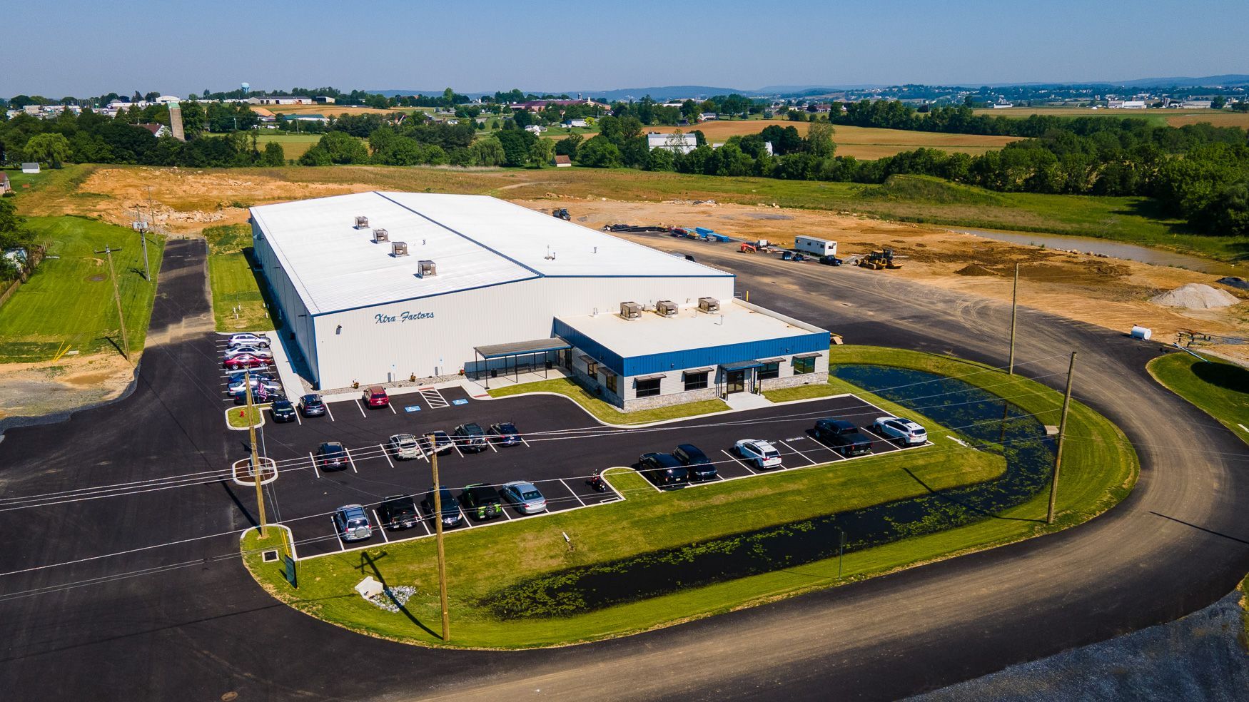 An aerial view of the Xtra Factors East Earl, PA building with a parking lot in front of it.