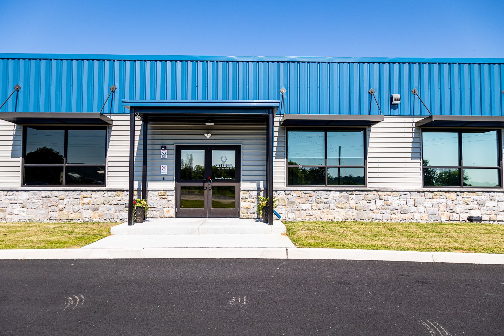 The Xtra Factors East Earl, PA building with a blue roof and a lot of windows