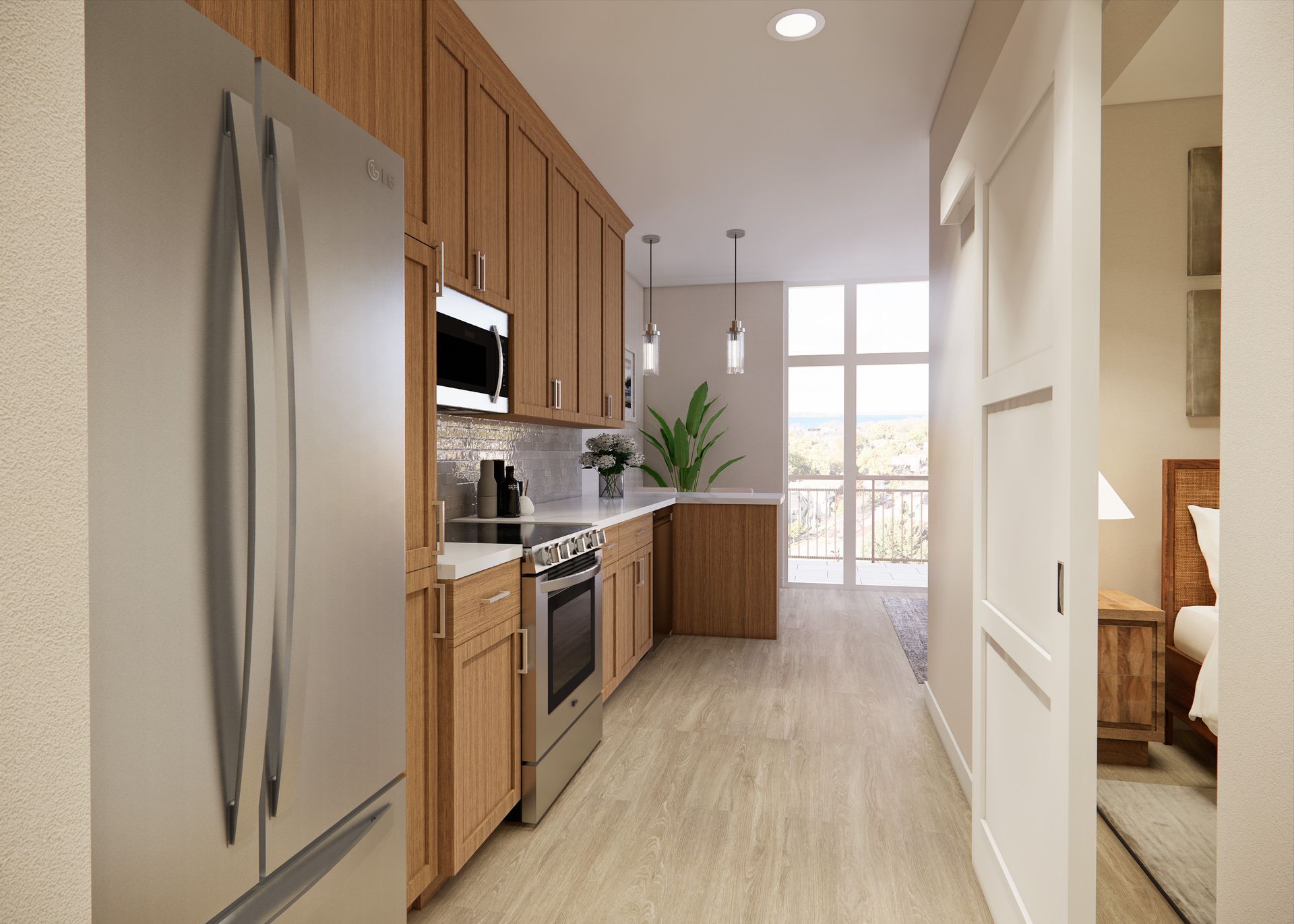 A kitchen with wood cabinets and stainless appliances, leading to a sunlit room with a balcony view.