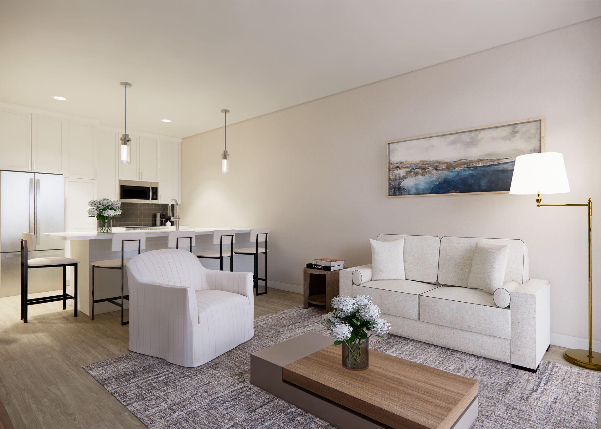 A modern living room with a white sofa, armchair, coffee table, and an open kitchen with a breakfast bar.