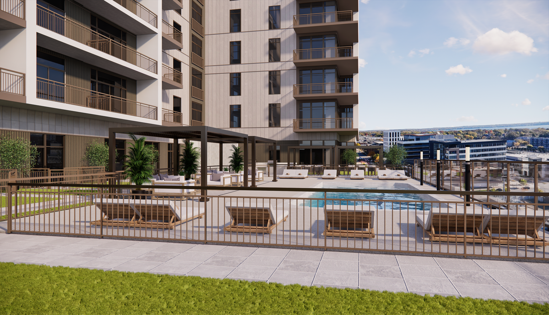 Rooftop pool deck with lounge chairs and building in the background on a sunny day.