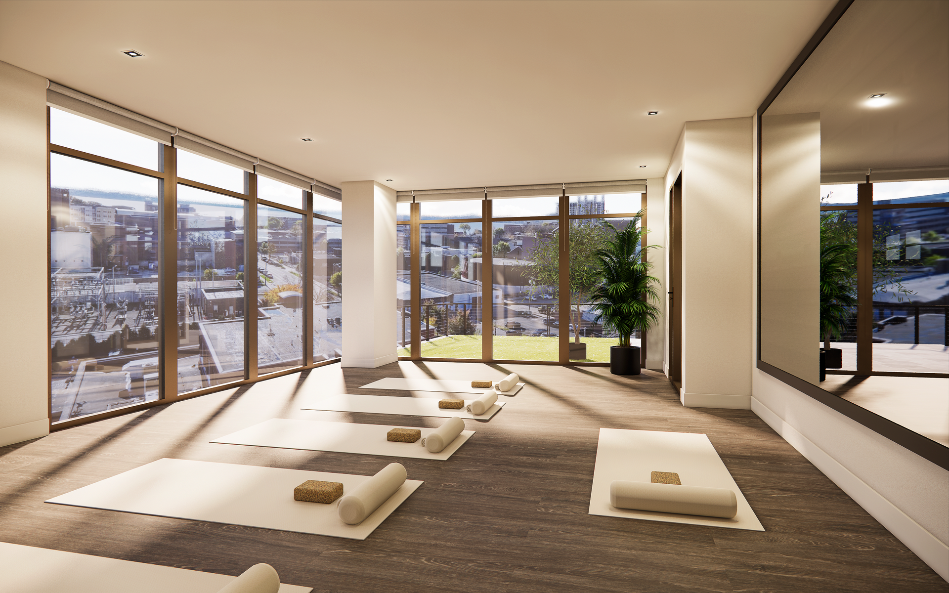 Yoga studio with mats, large windows overlooking a city, and a full-length mirror.
