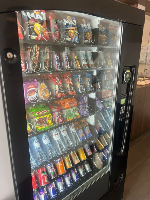 Een automaat gevuld met veel snacks en drankjes.