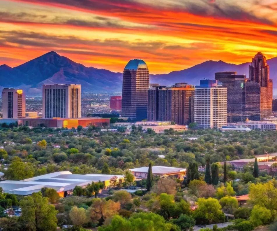 Phoenix, Arizona skyline at sunset with mountains in the background; colorful sky, buildings, trees.