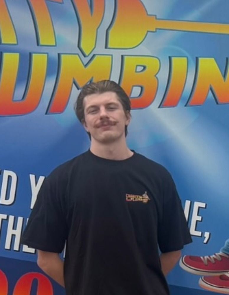 Woman in gray/blue shirt smiles in front of a service truck with text and shoe graphic.