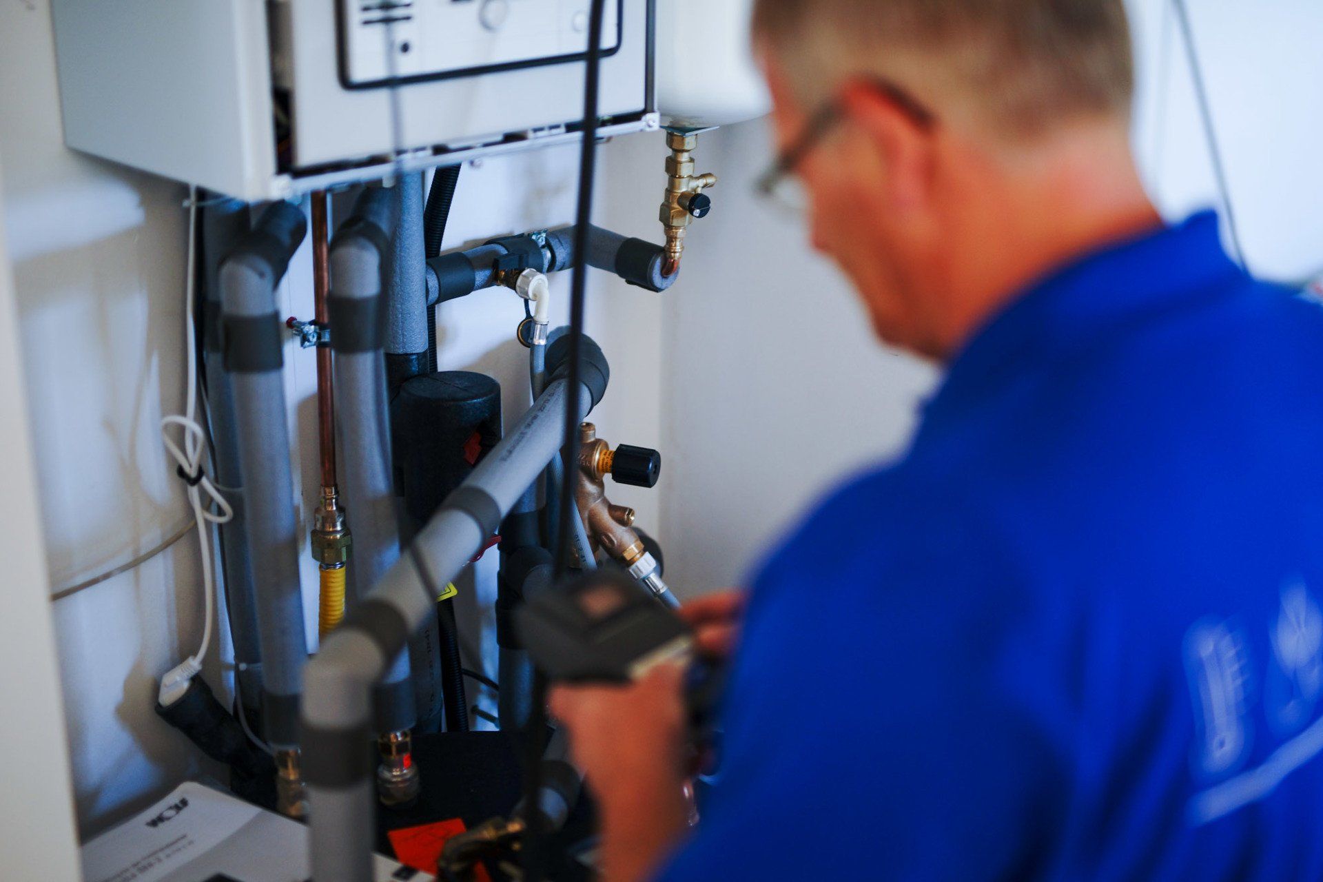 Ein Mann in einem blauen Hemd arbeitet an einem Kessel