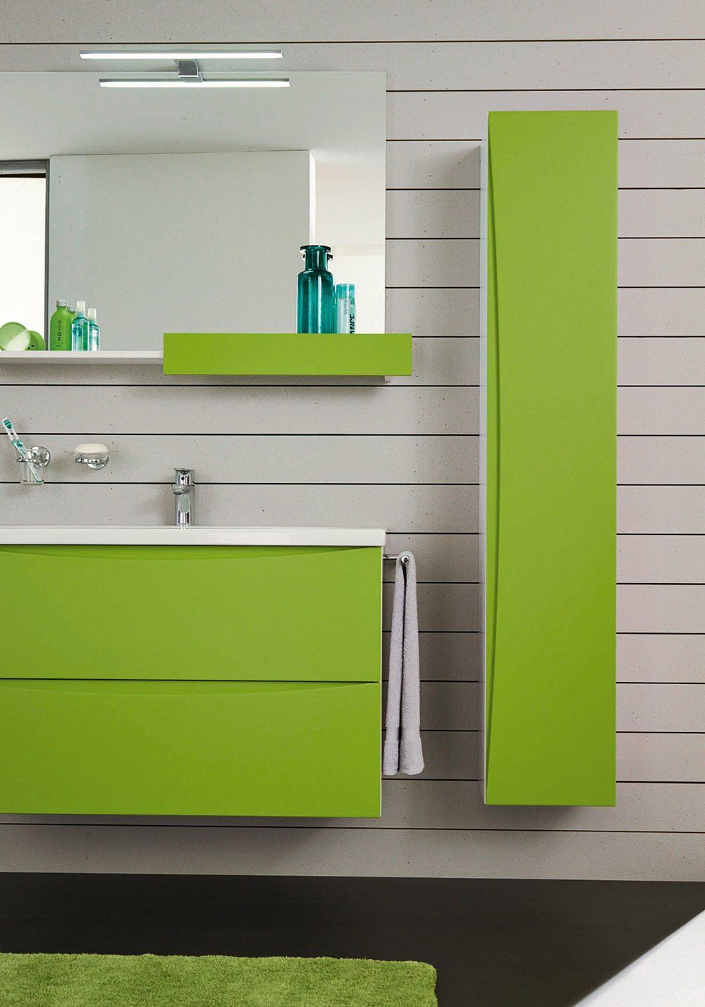 Ein Badezimmer mit grünen Schränken und einem Spiegel