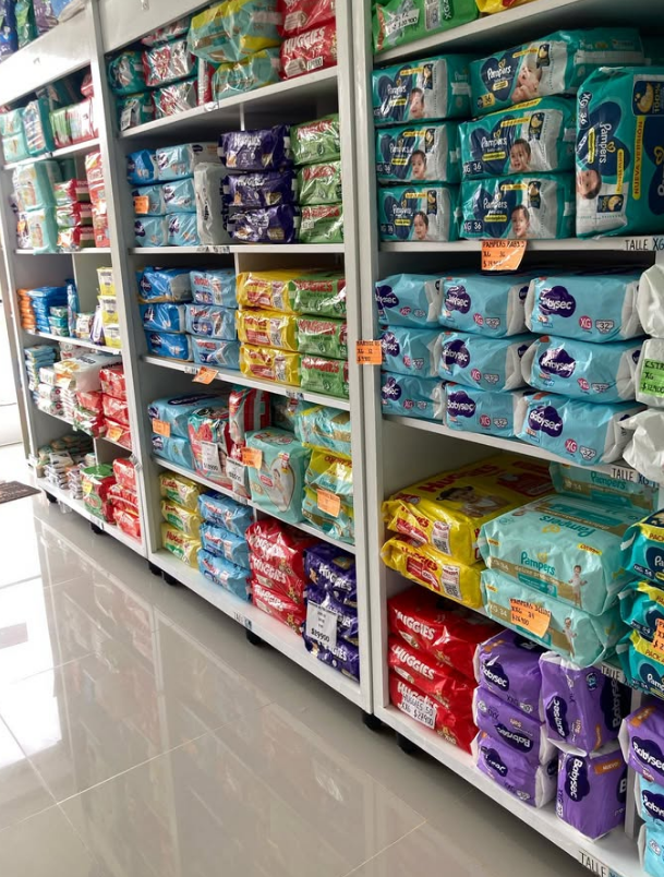 Una fila de estantes llenos de muchos pañales en una tienda.
