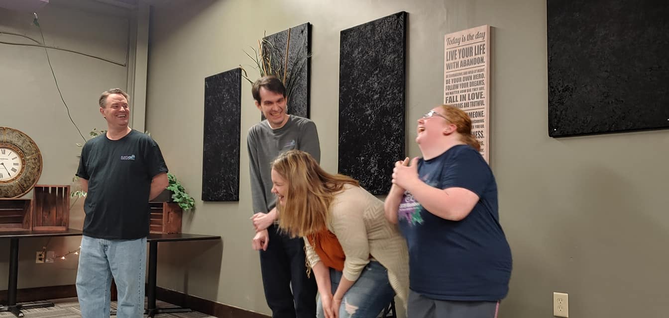 A group of people are standing next to each other in a room.