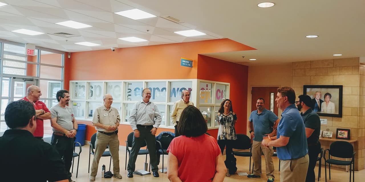 A group of people are standing in a circle in a room.