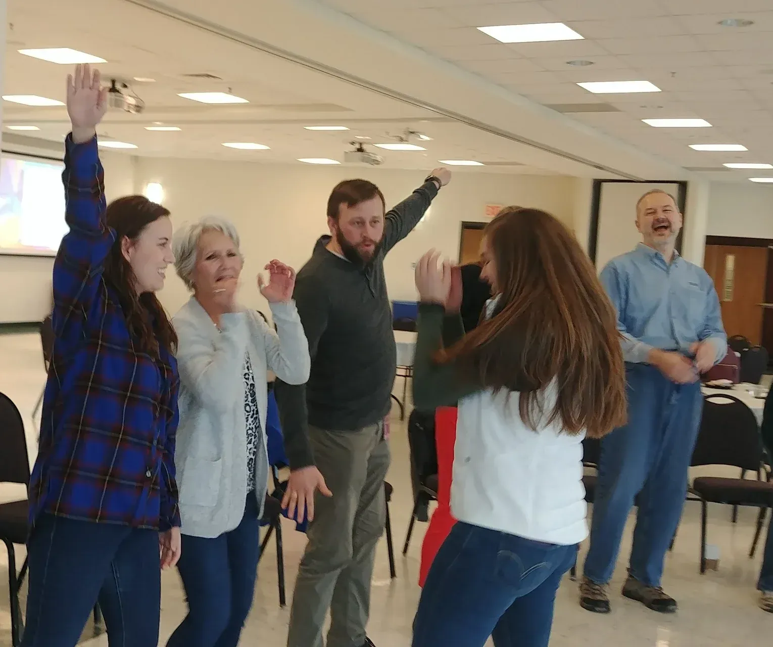 A group of people are dancing together in a room