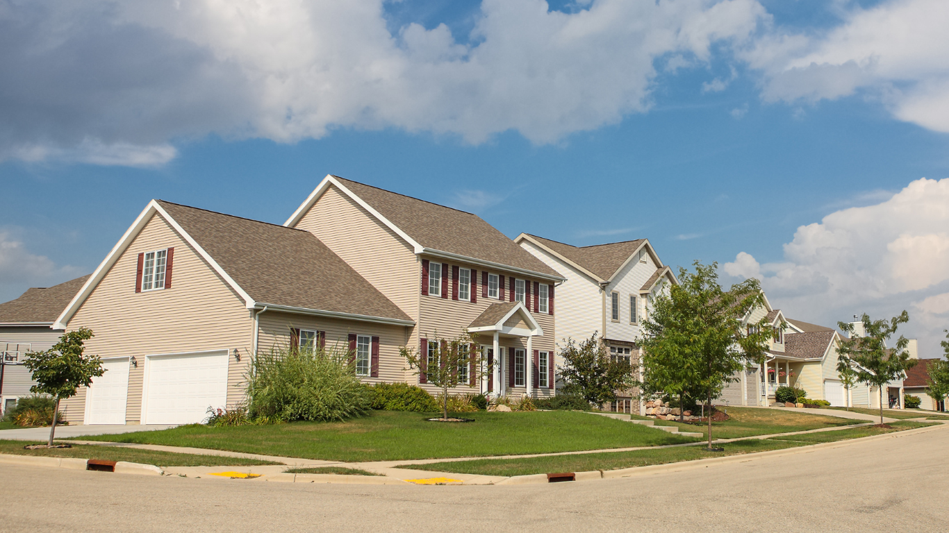Brown metal roof of a house, with visible ridgeline and overcast sky in the background.