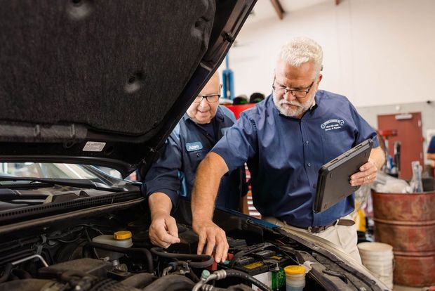 Two mechanics examining a car engine in a garage | Stephen's Automotive