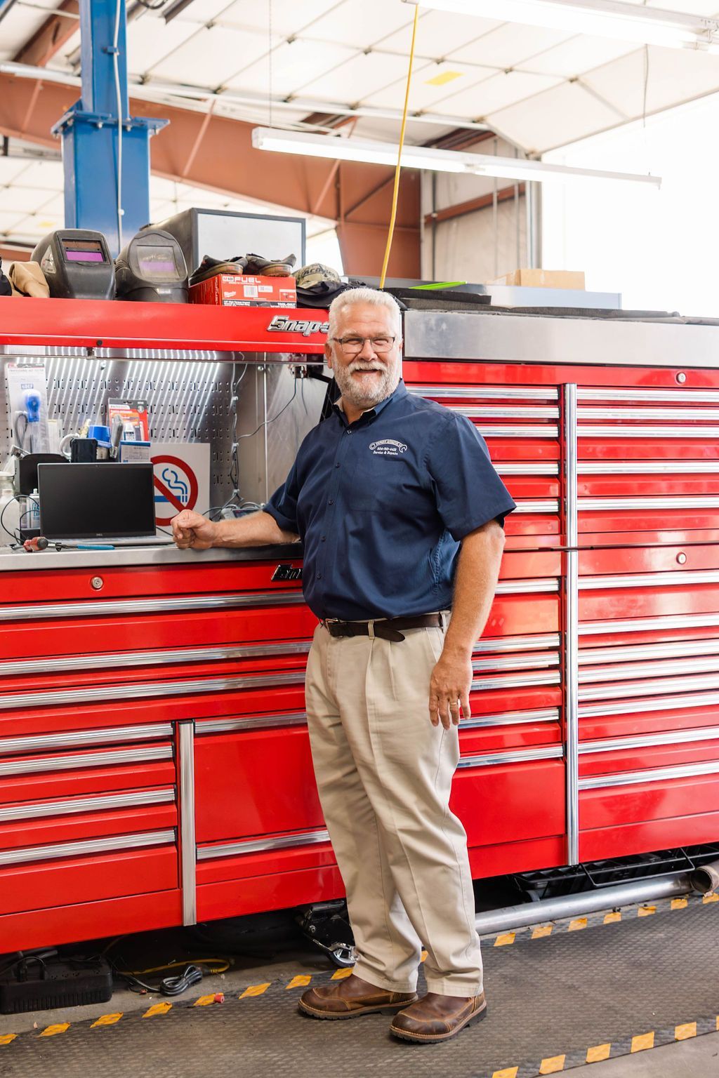 Owner stands beside a red tool cabinet in a garage | Stephen's Automotive