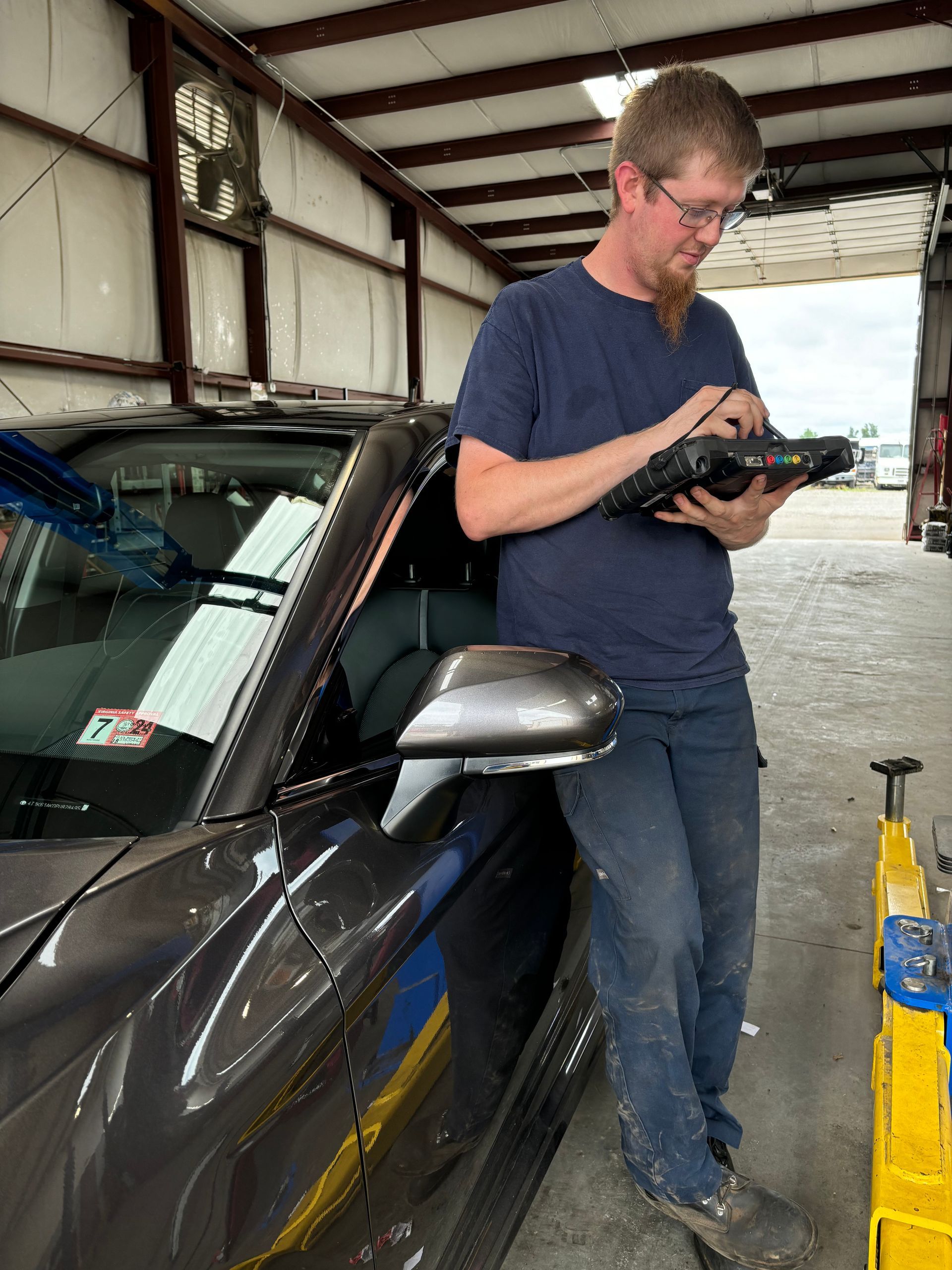 Mechanic in a garage diagnoses car with a tablet | Stephen's Automotive