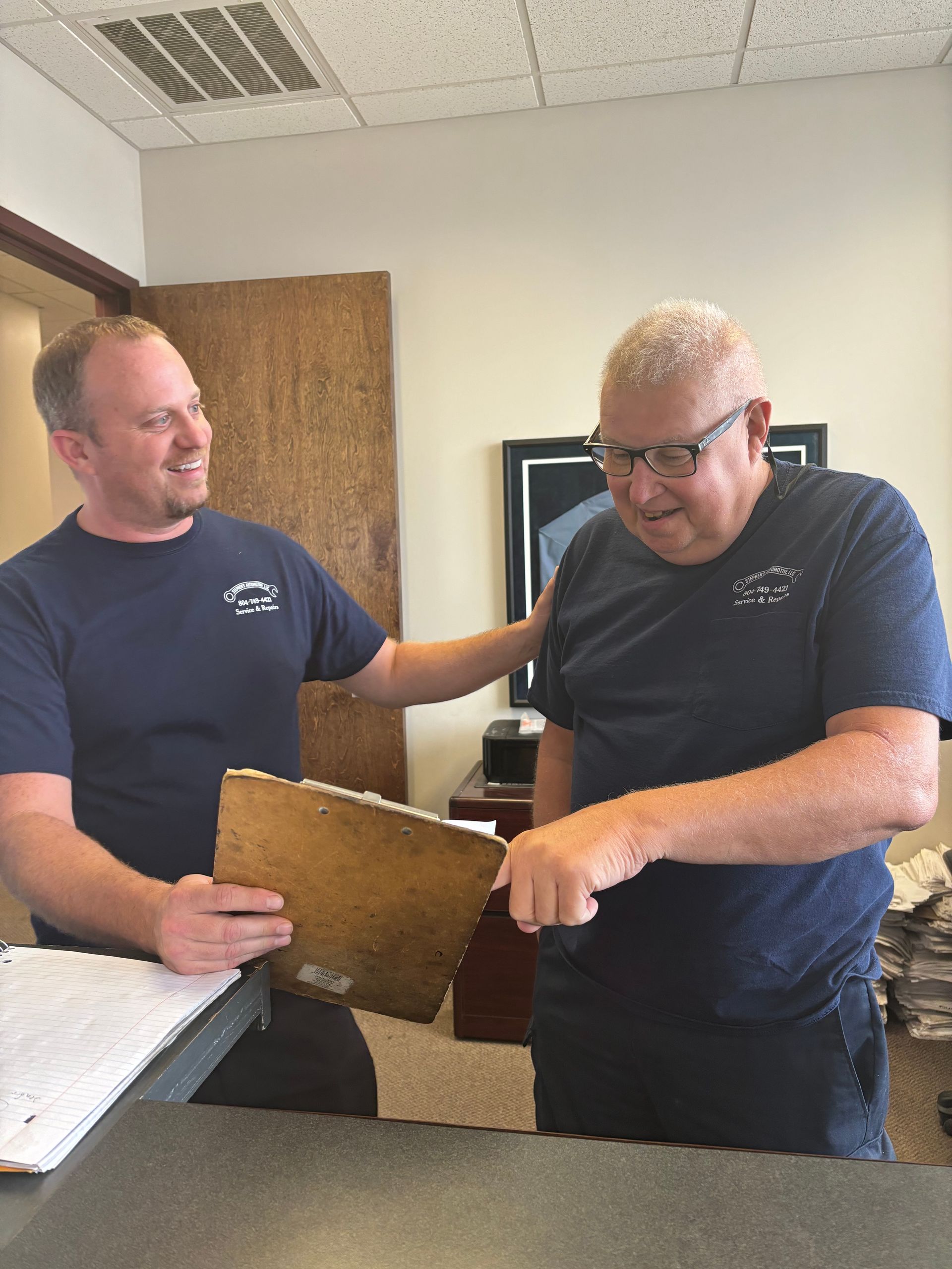 Mechanics looking at a clipboard | Stephen's Automotive