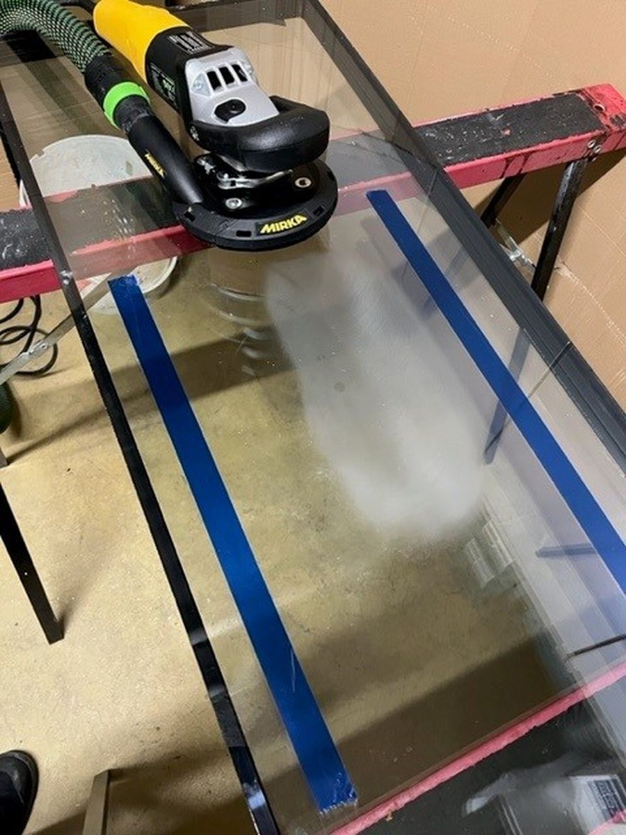 Auf einem Glastisch steht ein Schleifgerät.