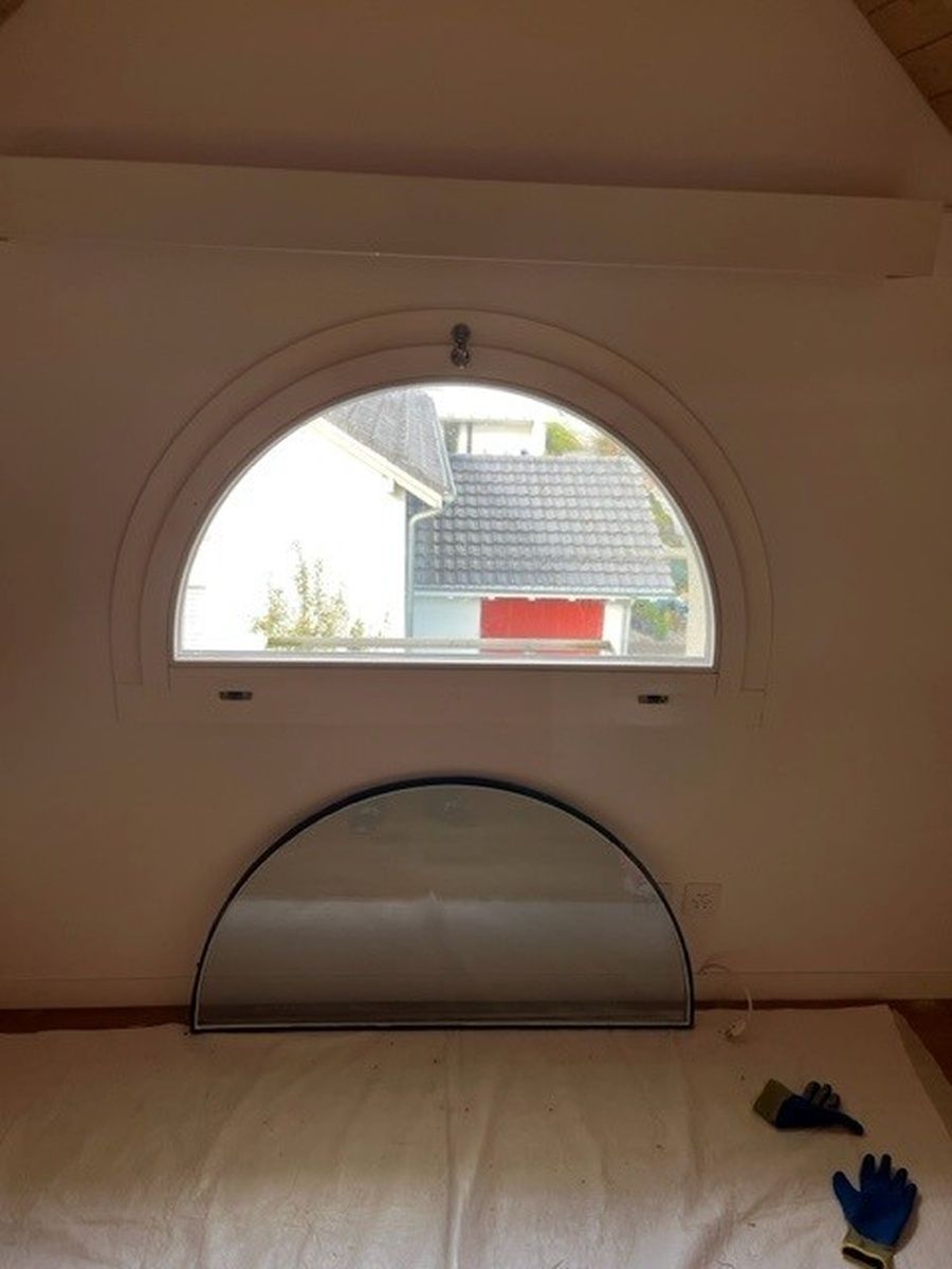 Ein Schlafzimmer mit einem Bett und einem Fenster mit Blick auf ein Haus.