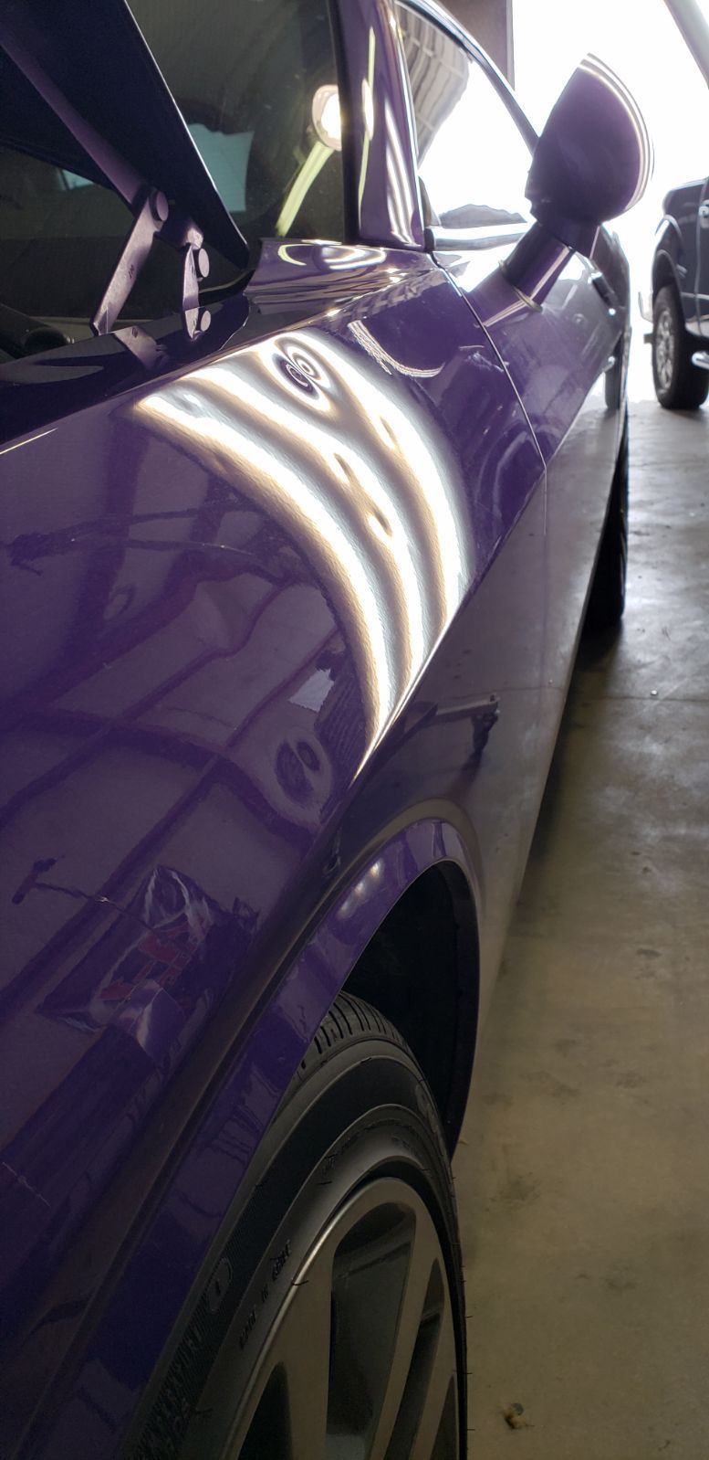 a close up of a purple car parked in a garage.