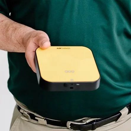 Home Inspector holding a small yellow and black square device, possibly a tech product.