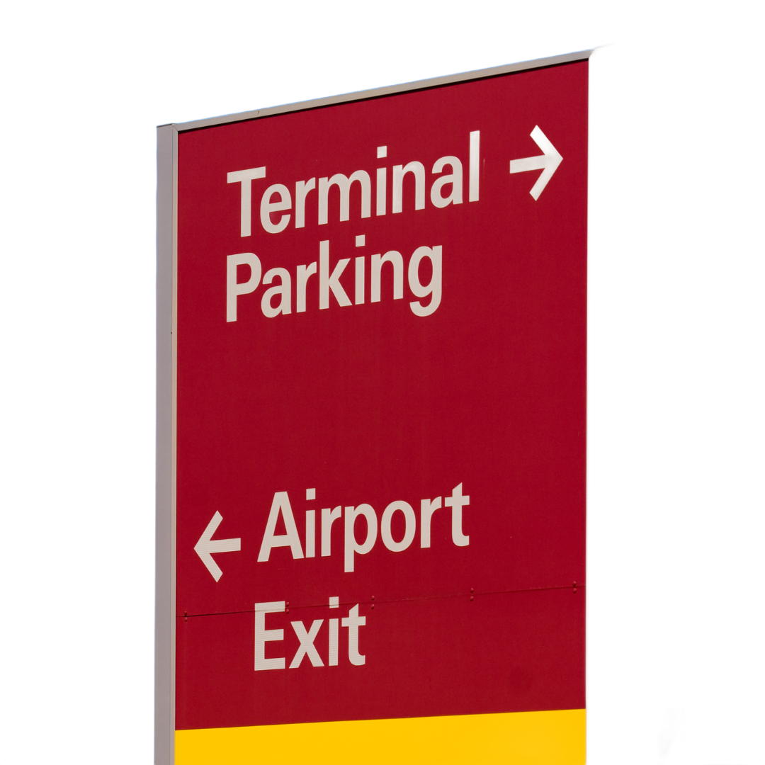 Red airport sign: Terminal Parking (right arrow), Airport Exit (left arrow).
