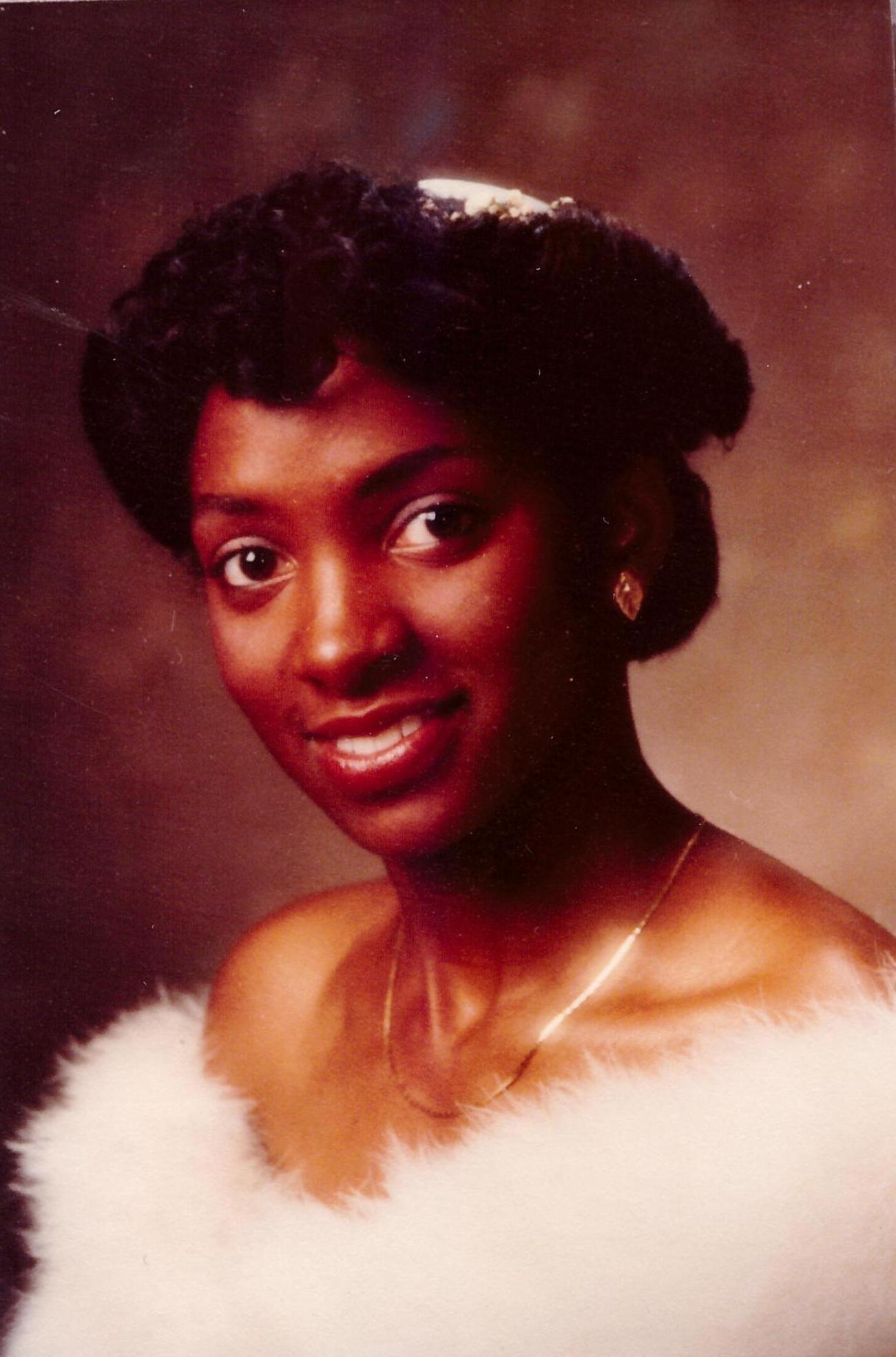 A woman in a white dress is smiling for the camera.