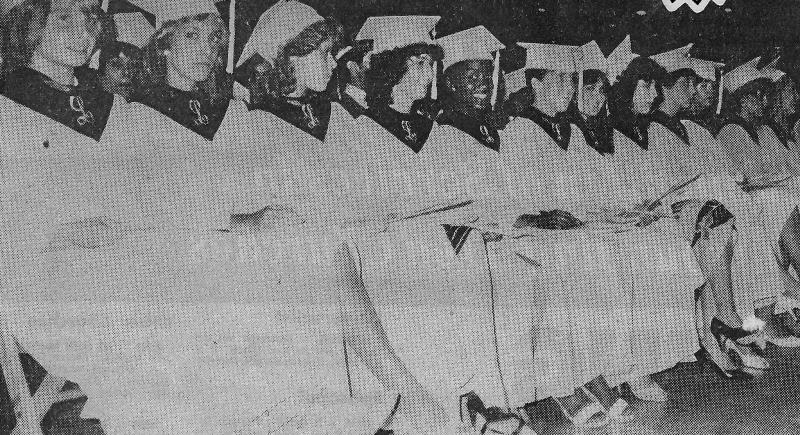 A black and white photo of a group of people wearing graduation caps.